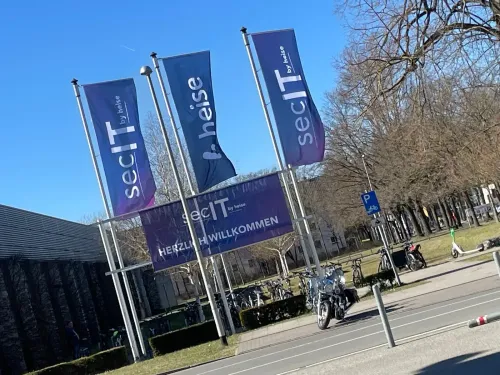 Das Außengelände; sonnig und wolkenlos, die Flaggen mit dem Logo der secIT flattern im Wind
