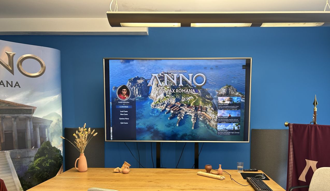 Der Titelbildschirm von ANNO 117: Pax Romana auf dem großen Screen.