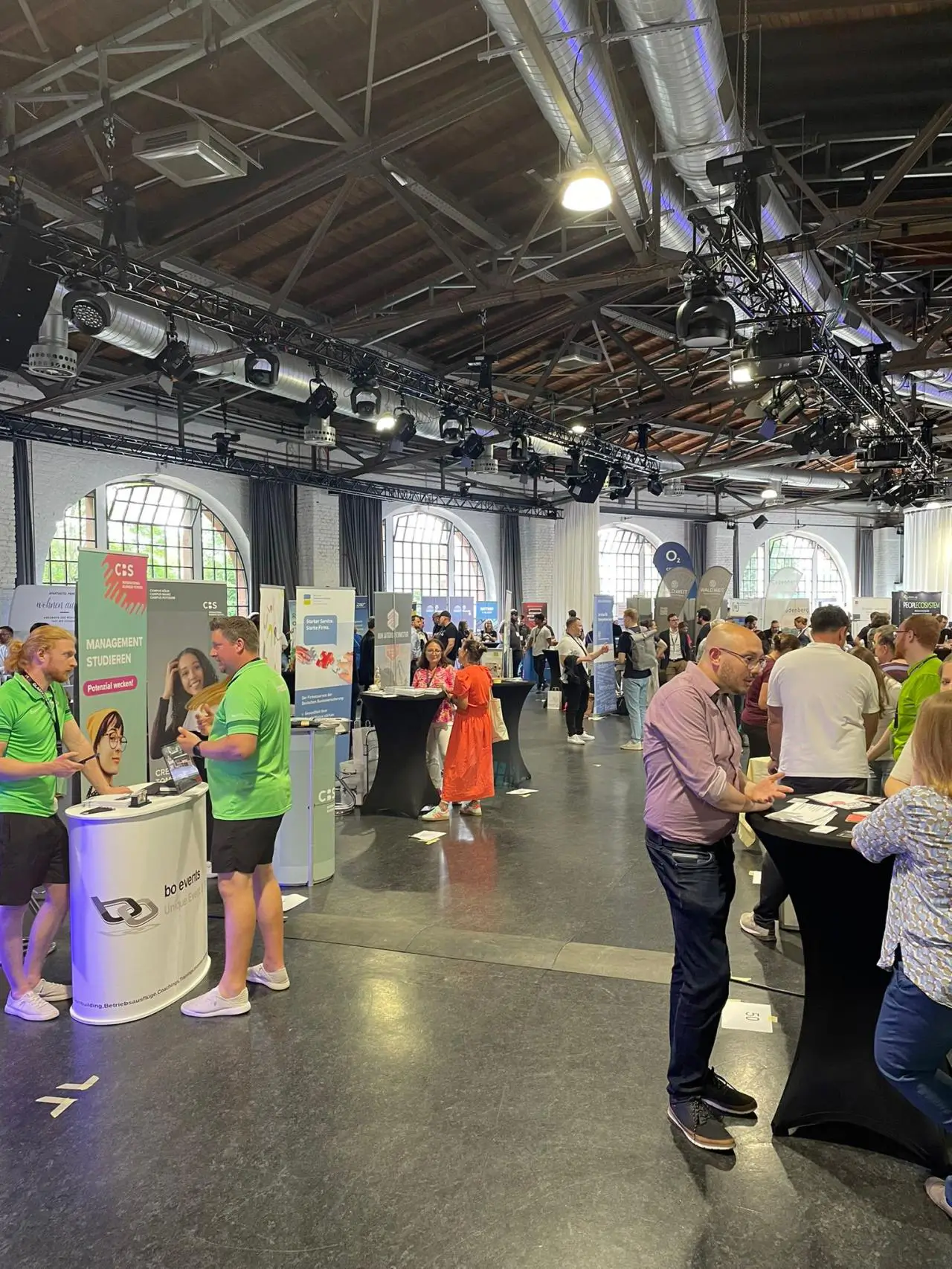 Die Präsentation wird per Beamer an die Leinwand geworfen, in der unteren rechten Ecke sind zwei bunte Ballons platziert, die zusammen die Zahl 50 zeigen.