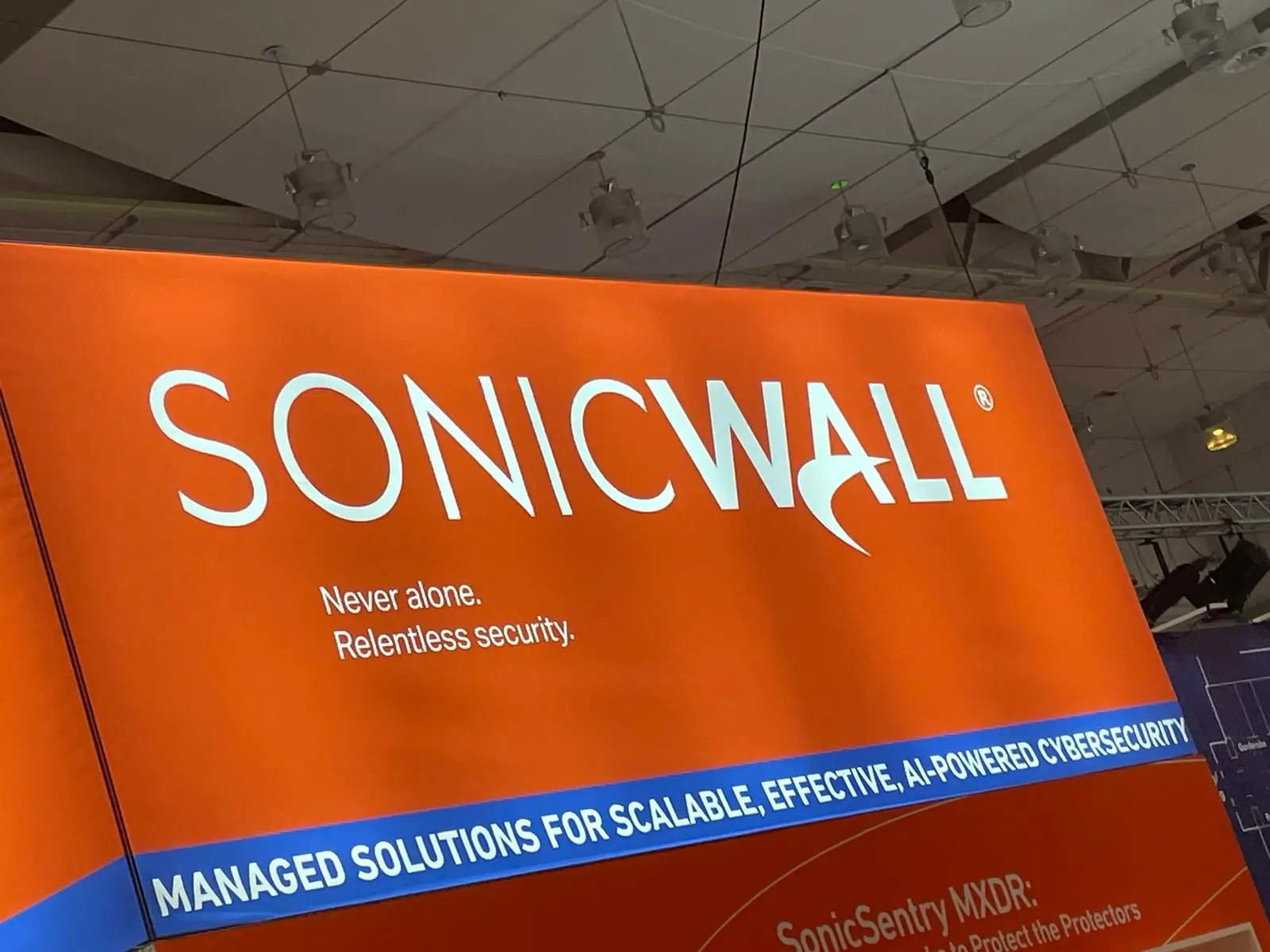 Im Inneren der secIT: Logo SONICWALL Management Solutions; weißer Text auf orangem Hintergrund