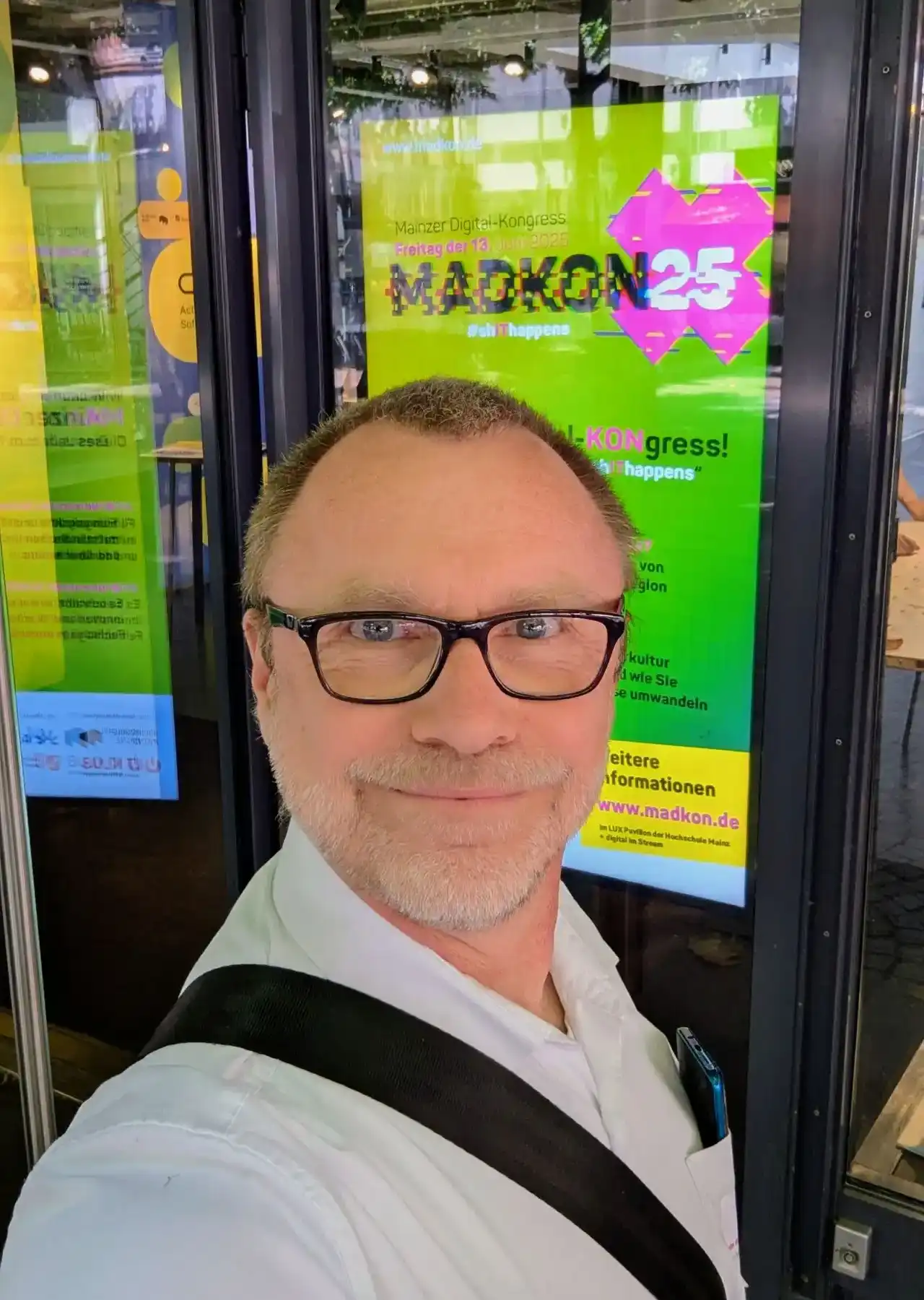 Selfie von Peter Winninger vor einem MADKON Plakat